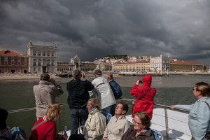 Portugal, Lisbon, 2010. Tourists capture a view from the river Tagus of the famous Praça do Comércio square also known as Terreiro do Paço.