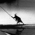 Mali, Mopti. 1986. A rower navigates his canoe across the river Niger at sunset.