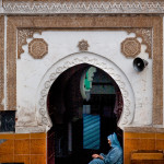 Morocco, Marrakech. 2010. An old man sits at the entrance of a mosque hoping for alms.