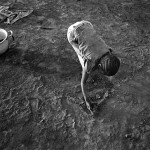 Guinea-Bissau, K3 village, on the outer marshes of the Cacheu river. 2005. A girl collects silt from the river forelands that were once fertile rice fields.