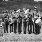 Zimbabwe, Domboshawa. 1989. A military band plays while two little children dance on the lawn.