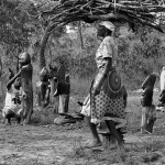 Zimbabwe, Tengenenge, Mvurwi.1988. Sculptor Barankinya Costa displays his work next to his house whille his mother returns from the field with fire wood. Some 40 sculptors work in Tengenenge, producing the highly acclaimed Shona works of art.