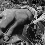 Zimbabwe, Mvurwi. 1988. Sculptor Samwell Chirume sits next to his creation at the Tengenenge community. Some 40 sculptors work here, producing the highly acclaimed Shona works of art.