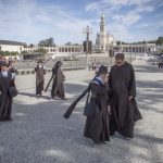 Portugal, Estremadura, Cova de Iria, Fatima. 2016. A group of foreign religious nuns and a priest walk on the square of the Sanctuary of Fatima with the basilica on the background.