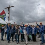 Portugal, Estremadura, Cova de Iria, Fatima. 2017. A joyous group of South African pilgrims waives the national flag at the sanctuary in Fatima.