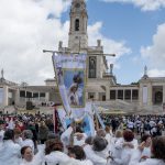 Portugal, Estremadura, Cova de Iria, Fatima. 2017. A group of Portuguese pilgrims arrives with banners at the sanctuary in Fatima and embrace each other upon the successfully completed walking journey.