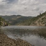 Portugal, Alto Douro. 2017. View at the River Tua valley near the former railway station of São Lourenço (marker 15) where the railway is being submerged with the ballast just slipping beneath the water.